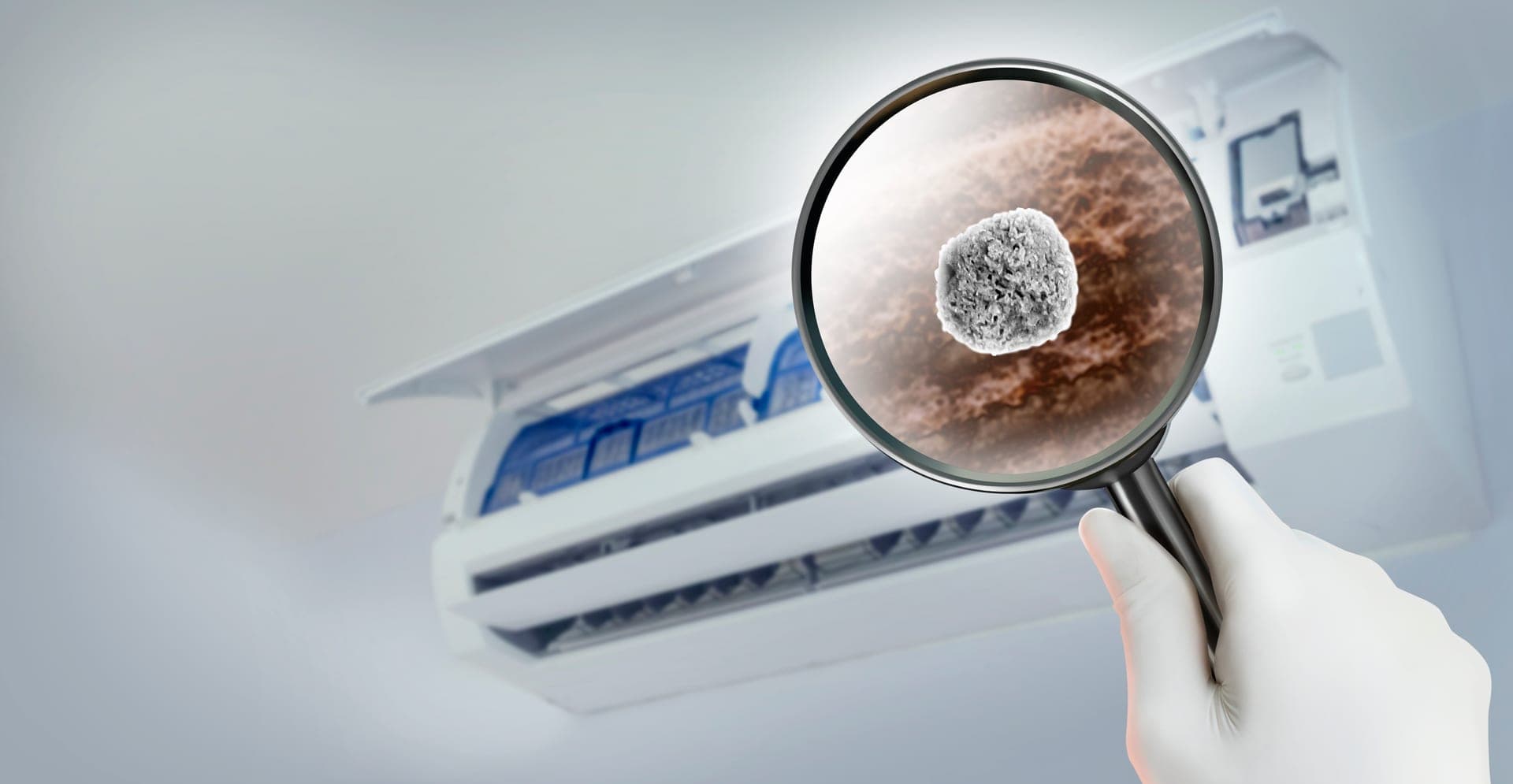 Magnifying glass showing mold inside an air conditioning unit