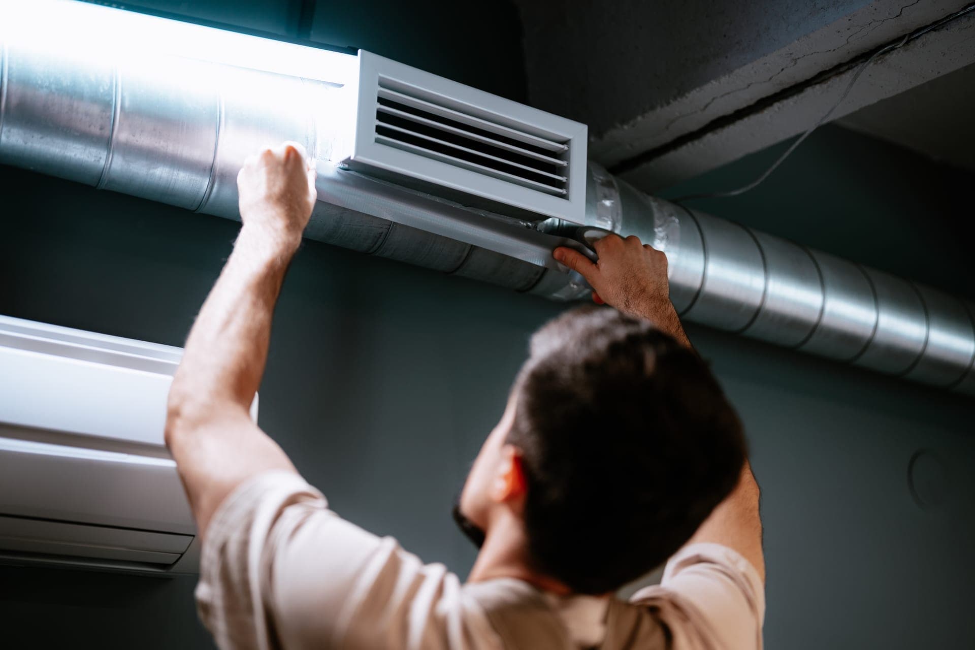 Technician inspecting air duct system